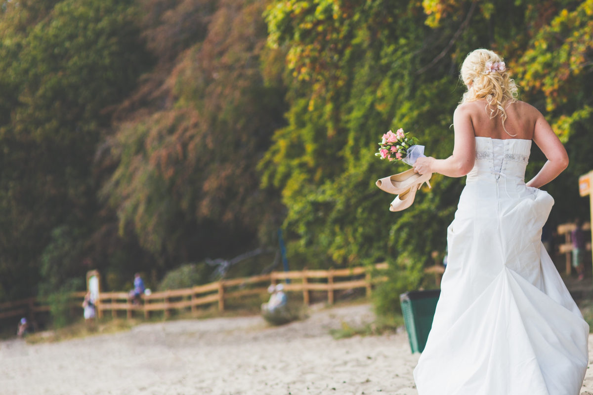 kaboompics.com_Bride walking alone with flowers and shoes